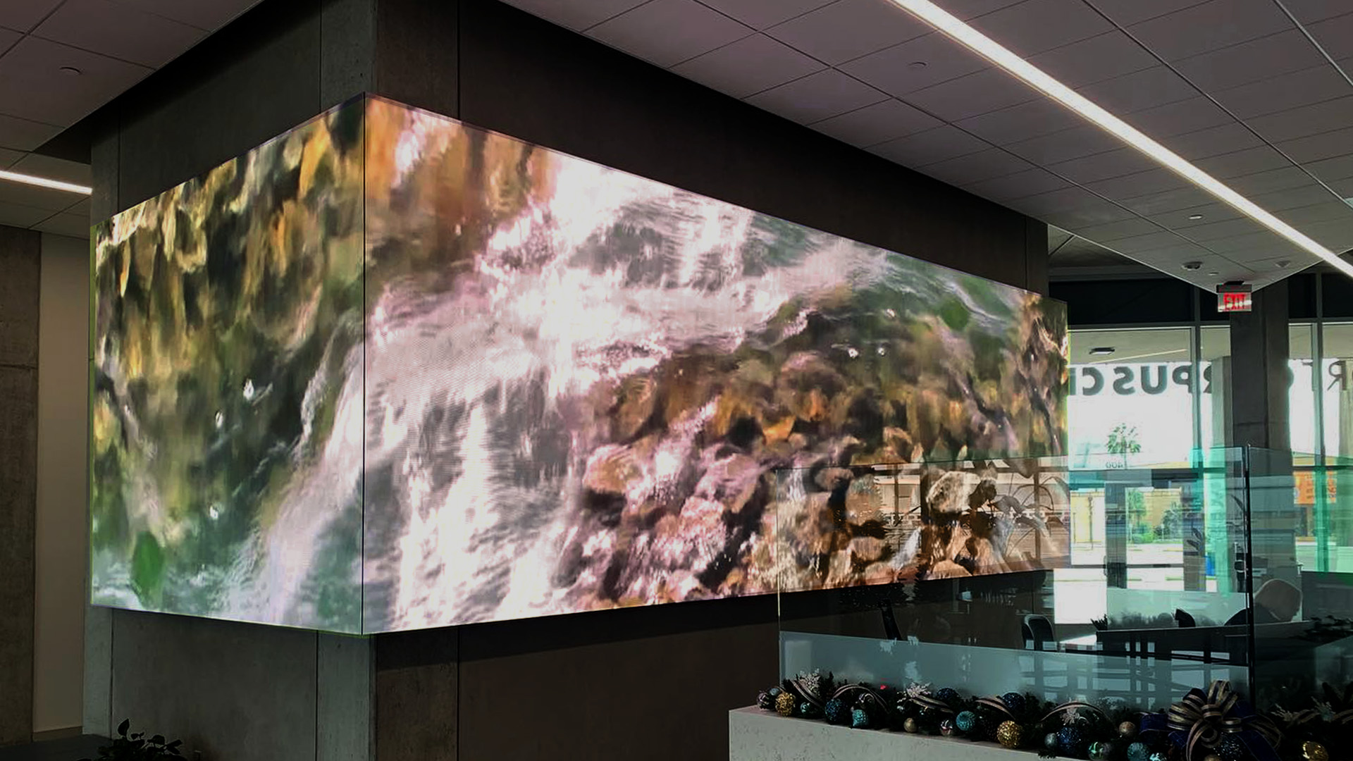 Screen on column in lobby showing water flowing over rocks